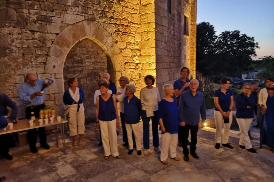 Le chœur devant une arche de pierre éclairée, à la tombée du jour