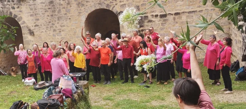 Les choristes bras levés devant les remparts