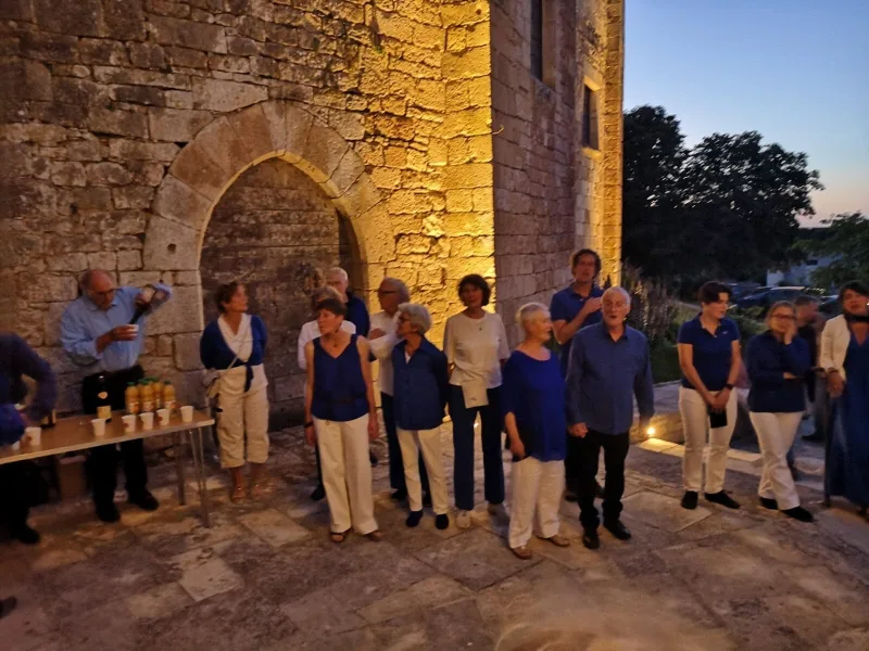 Le chœur devant une arche de pierre éclairée, à la tombée du jour