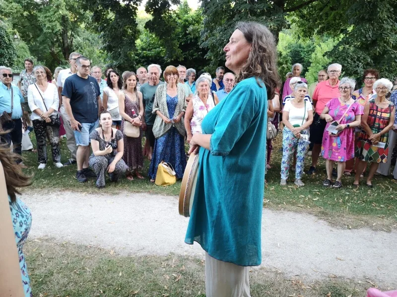 La cheffe de chœur, bendir à la main, devant le public en plein air