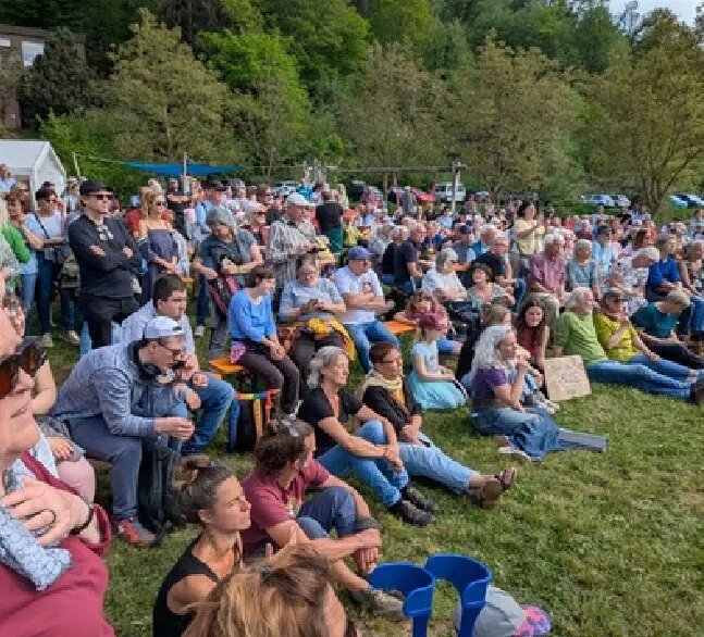 Le public installé dans l’herbe pour un concert en plein air